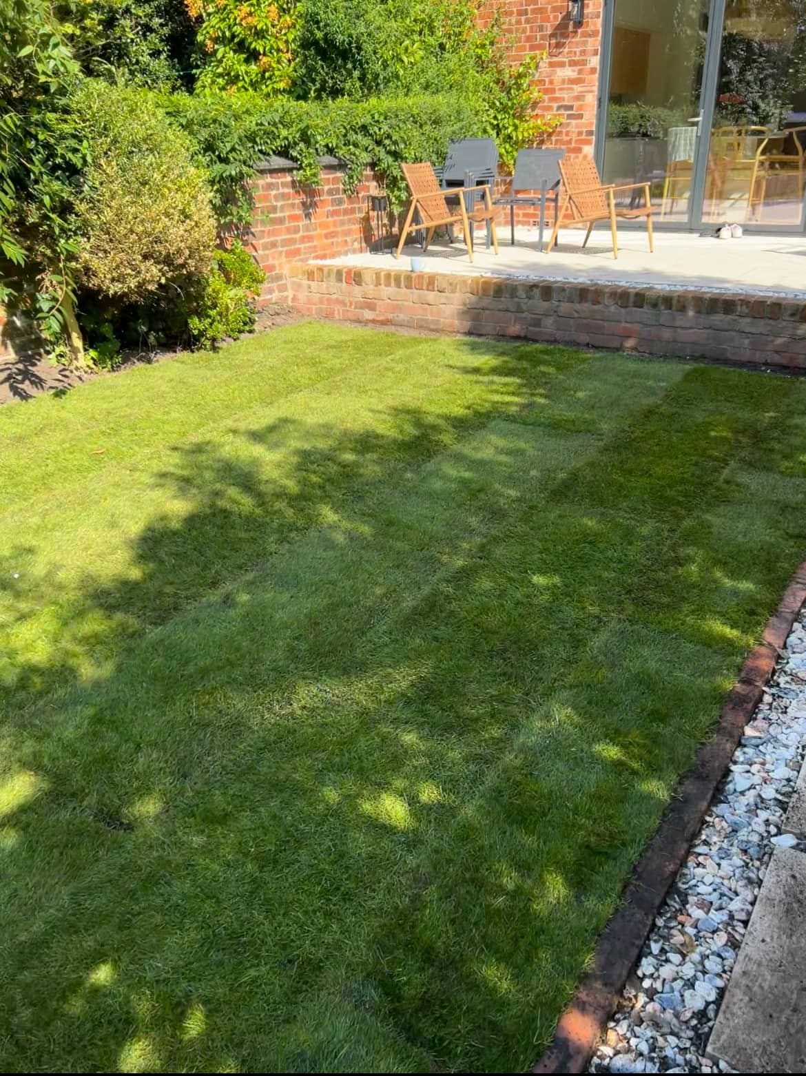 After: landscaped rear garden with striped lawn and pergola